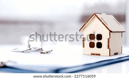 keychain of keys in the form of a house on the contract of sale of housing. High quality photo