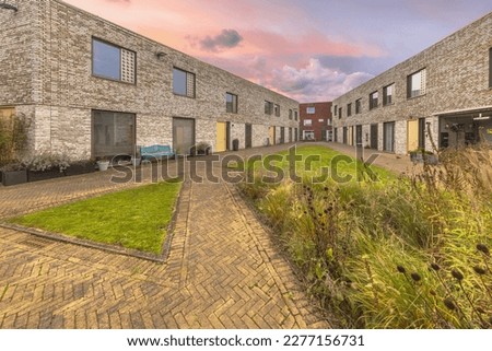Modern living community in the dutch city of Groningen. Contemporary Apartments in residential low rise building exterior. Housing structure with communal garden. Examplary house in Europe.  Royalty-Free Stock Photo #2277156731