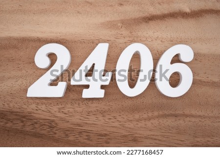 White number 2406 on a brown and light brown wooden background.