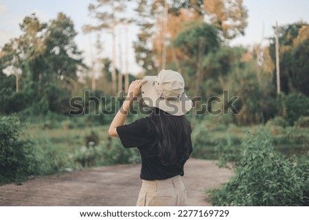 Woman in a hat on a background of forest and trees.