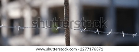 Close-up of security barbedwire fence, wire with clusters of short, sharp spikes. Fence or warfare obstruction, correctional institution concept Royalty-Free Stock Photo #2277176371