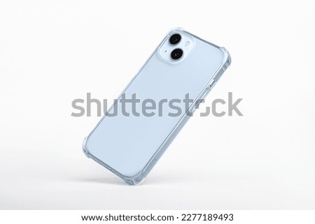 Blue iPhone 14 in clear silicone case falls down, back view isolated on gray background, phone case mockup