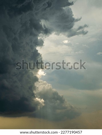 Majestic cloud formation splitting the sky in half with sunrays and stormy clouds