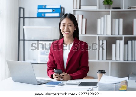 Beautiful business woman sitting and look at the camera at the office.