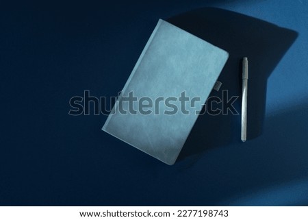 Simple blue diary on a colored background, top view