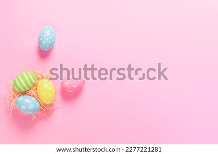 Happy Easter holiday greeting card concept. Colorful Easter Eggs pastel pink background. Top view, flat lay, copy space.