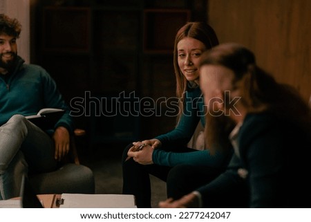 A close up shot of young male and female coworkers listening to their colleague talking
