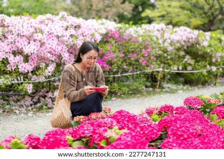 Woman use cellphone to take photo on Hydrangea flower in park