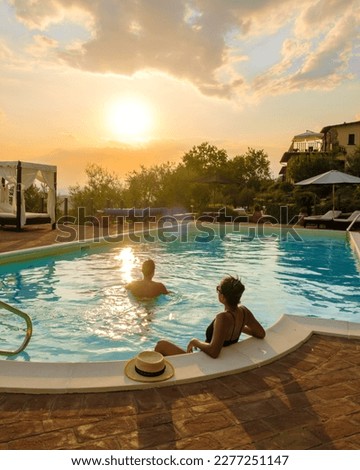 Luxury country house with swimming pool in Italy. Pool and old farmhouse during sunset in central Italy. Couple on Vacation at a luxury villa in Italy, men and woman watching the sunset.  Royalty-Free Stock Photo #2277251147