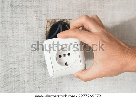 Dangerous bad,broken socket,plug in bathroom,falling out of wall. Outlet installation in old apartment. Poor electrical wire,repair.Terrible do-it-yourself repairmen.Short circuit risk,electric shock. Royalty-Free Stock Photo #2277266579