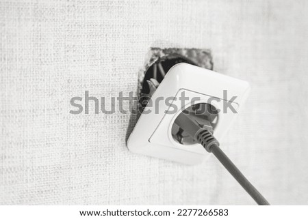 Dangerous bad,broken socket,plug in bathroom,falling out of wall. Outlet installation in old apartment. Poor electrical wire,repair.Terrible do-it-yourself repairmen.Short circuit risk,electric shock. Royalty-Free Stock Photo #2277266583