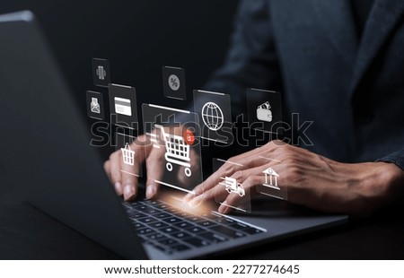 Businessman using laptop computer to input order with icons shopping trolley, credit card, delivery truck, bank, shopping basket, wallet for online shopping and e-commerce technology concept.