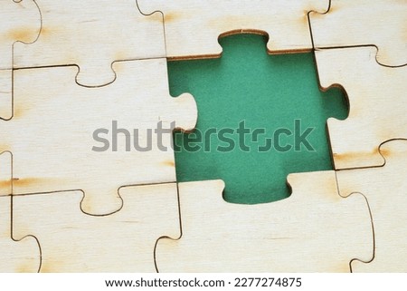 Incomplete and absence wooden puzzle piece with green backdrop. Missing piece. Mental health concept. Symbol of problem solving. Business creative solution. Communication idea. Hobby, play, fun game