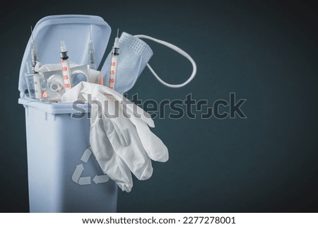Medical waste concept, Open garbage full of pills, syringes, bandages, masks, protective gloves. Utilization and storage of hospital waste, copy space Royalty-Free Stock Photo #2277278001