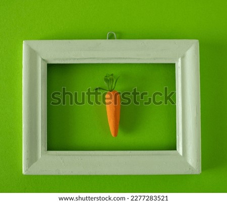 Easter carrots framed in a white picture frame hanging on a gree