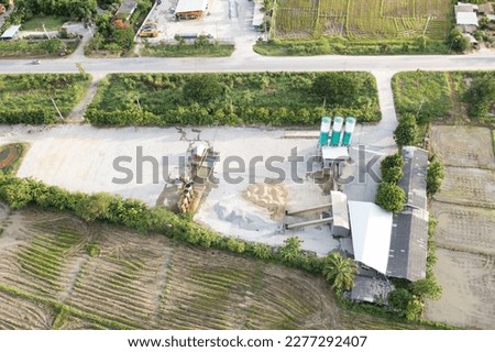 Concrete plant or batching plant in top view. Building and equipment for production ready mix concrete by mix aggregate material i.e. cement, water, sand, rock or gravel for construction work. Royalty-Free Stock Photo #2277292407