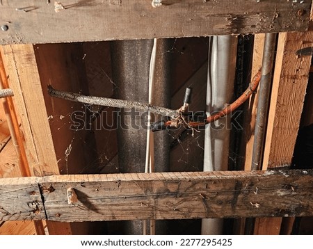 A closeup of loose electrical wires hanging from a ceiling.  Royalty-Free Stock Photo #2277295425