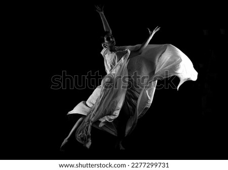 A dancer in a white robe on a black background Royalty-Free Stock Photo #2277299731