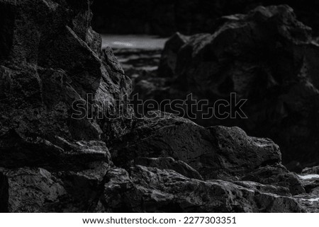 Very big and beautiful black rocks the power of the ocean black lave stone close up dark rocks wet Royalty-Free Stock Photo #2277303351