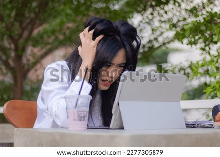 beautiful asian women formal explore cafe outdoor. girl stress unfinished work in front of tablet laptop in cafe oudoor landscape