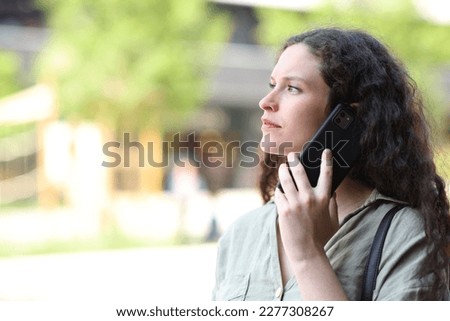 Woman talking on phone walking in the street Royalty-Free Stock Photo #2277308267