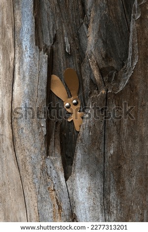 toy leather rabbit in a tree trunk