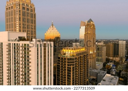 aerial shot of office buildings, skyscrapers in the city skyline at sunset with cars driving on the freeway in Atlanta Georgia USA