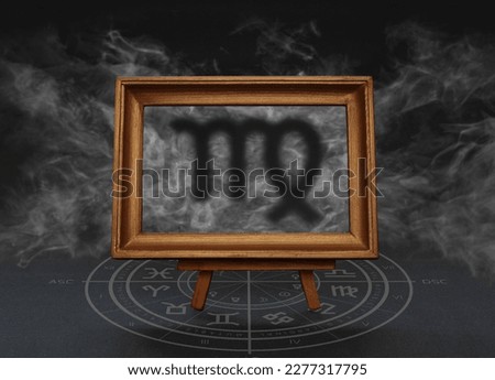 Abstract image of the sign of the zodiac Virgo against the background of smoke in a frame on a stand
