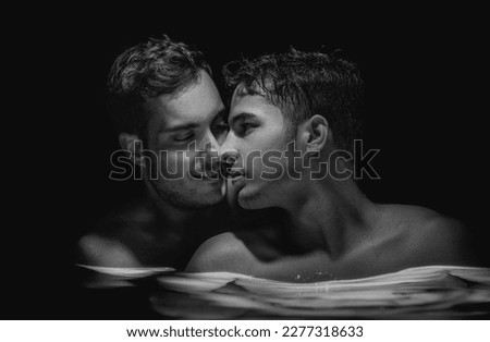Gay couple relaxing in swimming pool. LGBT. Two young men kissing and hugging. Black and white portrait. Handsome young male, romantic homosexual family in love. Happiness concept, LGBTQ Royalty-Free Stock Photo #2277318633