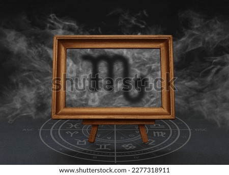 Abstract image of the sign of the zodiac Scorpio against the background of smoke in a frame on a stand