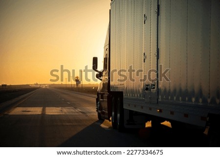 Long Haul 18 Wheel Truck driving on a highway at sunrise or sunset  Royalty-Free Stock Photo #2277334675