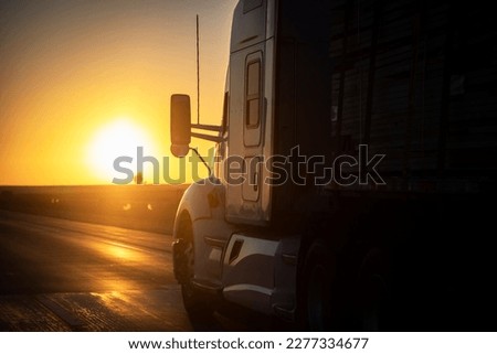 Long Haul 18 Wheel Truck driving on a highway at sunrise or sunset  Royalty-Free Stock Photo #2277334677