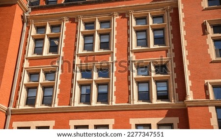 historic brick building structure with glass windows of urban arpartment building old residential construction in boston downtown street with blue sky and business concept symbolizing monotonous work