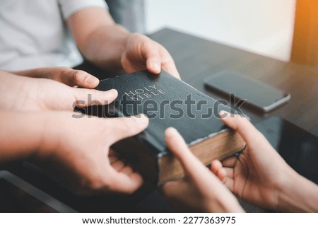 Concept of Christian ministry. Small groups pray together for the Christian mission. Mission to spread the gospel and religion of Christianity around the world. hands holding bible on wooden table. Royalty-Free Stock Photo #2277363975