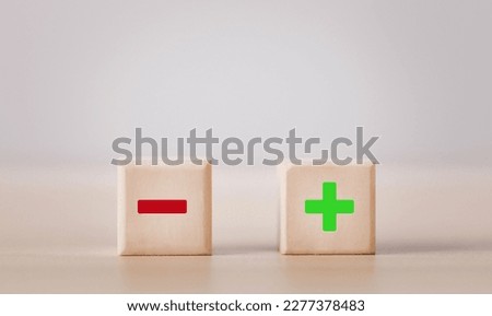 Wooden blocks showing plus and minus signs. The concept of antithesis. Decision making. Positive or negative business choice. Analysis of advantages and disadvantages Comparison