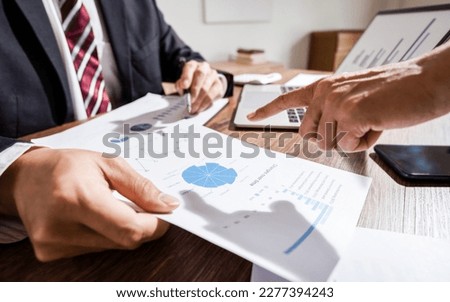 Business administrator calculates profit in a conference room.

