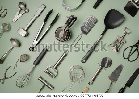 Kitchen utensils or cooking tools on green background, top view, flat lay. Kitchenware collection with copy space. Cooking background. Royalty-Free Stock Photo #2277419159