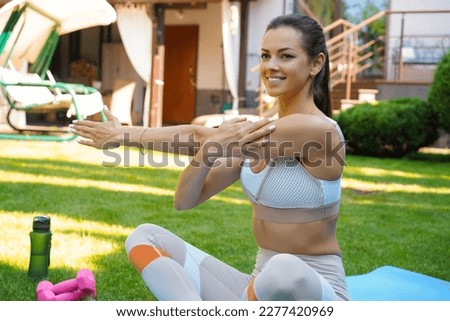 Fitness beautiful slim woman doing fitness stretching exercises outdoor at home. Sport, healthy lifestyle