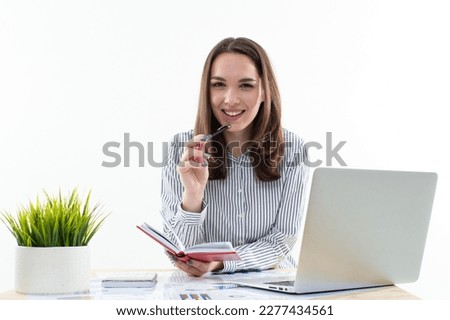 This modern businesswoman is hard at work, juggling multiple tasks as she efficiently manages her laptop and documents