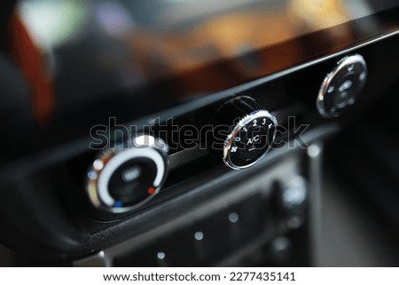 The process of choosing climate control in the car. Man regulating temperature on car air condition. Modern car interior