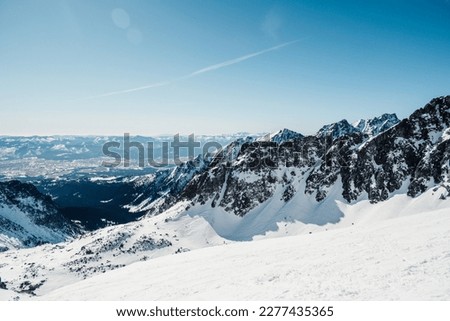 Alpine mountains landscape with white snow and blue sky. Sunset winter in nature. Frosty trees under warm sunlight. Wonderful wintry landscape. High Tatras, Slovakia
