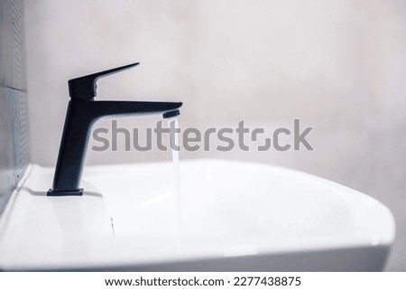 Water tap , faucet. Flow water in bathroom with sink. Modern clean hause. Hygiene concept.