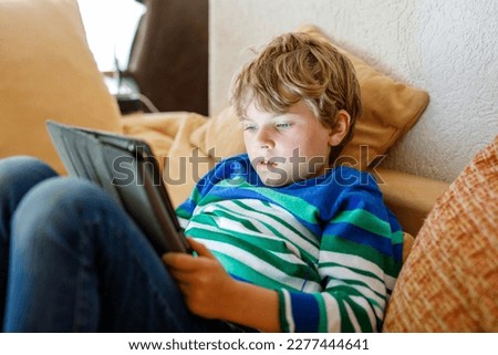 School boy with tablet computer. Schoolchild study online. Electronic device for learning, studying and playing at home. Little boy with laptop pc. Gadget and screen time for children. Kid at home. Royalty-Free Stock Photo #2277444641