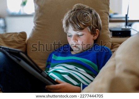 School boy with tablet computer. Schoolchild study online. Electronic device for learning, studying and playing at home. Little boy with laptop pc. Gadget and screen time for children. Kid at home. Royalty-Free Stock Photo #2277444705