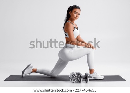Fitness woman doing lunges exercises for leg muscle training. Active girl doing front forward one leg step lunge Royalty-Free Stock Photo #2277454655