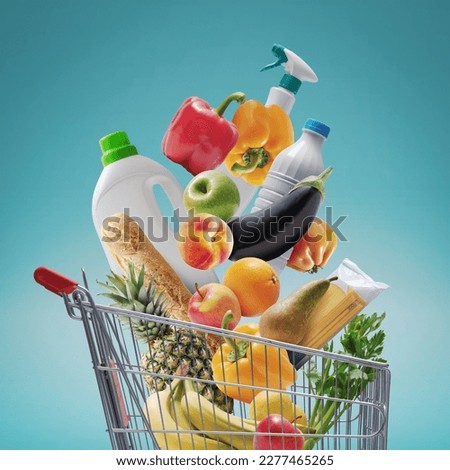 Fresh groceries and goods falling in a supermarket trolley, grocery shopping concept Royalty-Free Stock Photo #2277465265