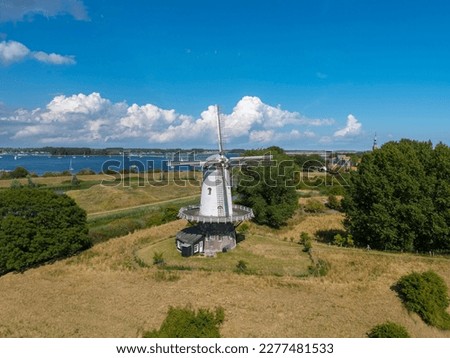 Aerial view with the windmill De Koe in Veere. In the background the inland water Veerse Meer. Veere is a city in the province of Zeeland in the Netherlands