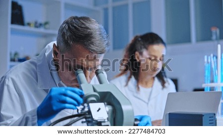 Oncology doctor examining tissue sample under microscope, clinical diagnostic lab Royalty-Free Stock Photo #2277484703