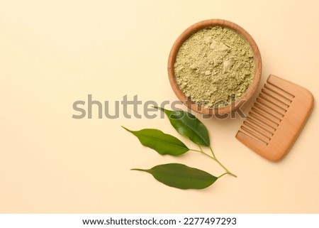 Henna powder, green leaves and comb on beige background, flat lay with space for text. Natural hair coloring