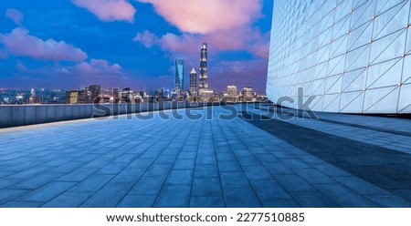 Empty square floor and city skyline with modern buildings at night in Shanghai, China.